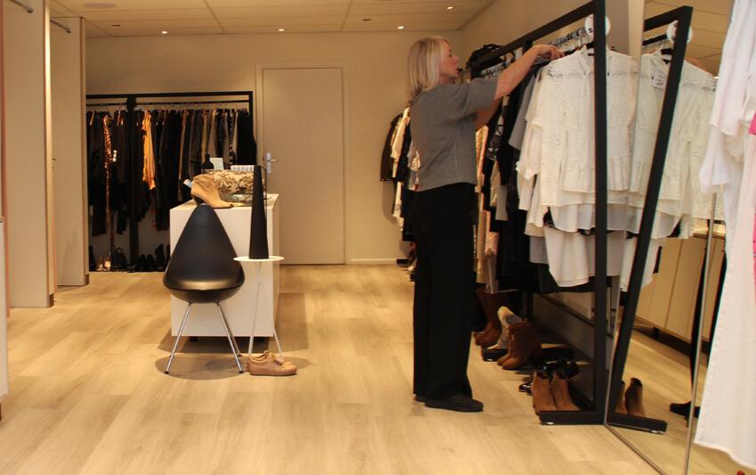 Binnen bij winkel Mevrouw jansen met rekken kleding